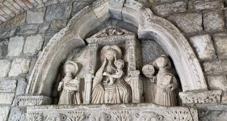 Relief de pierre complexe de figures religieuses intégré dans un mur.