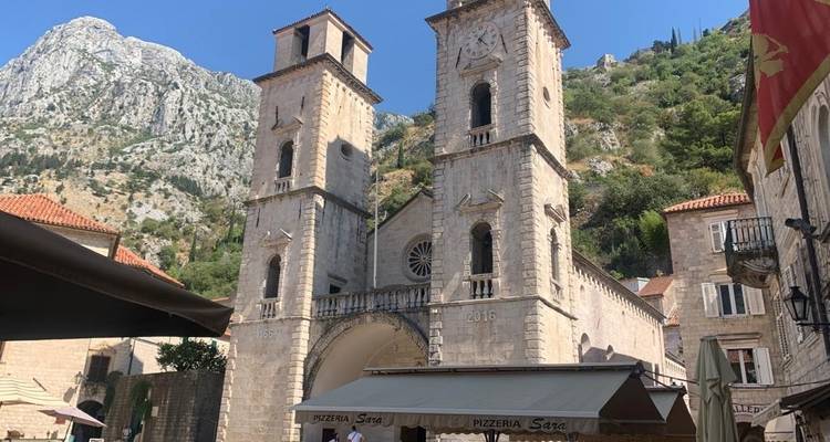 Tours jumelles d'une église avec un paysage montagneux en arrière-plan.