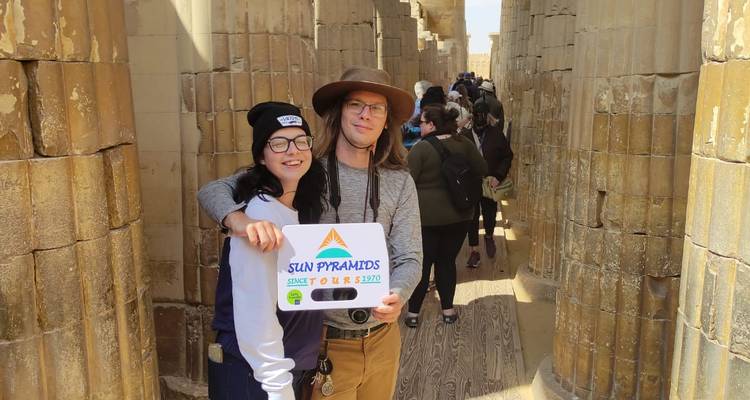 Stel dat poseert met een toeristenbord in een gang van een oude tempel.