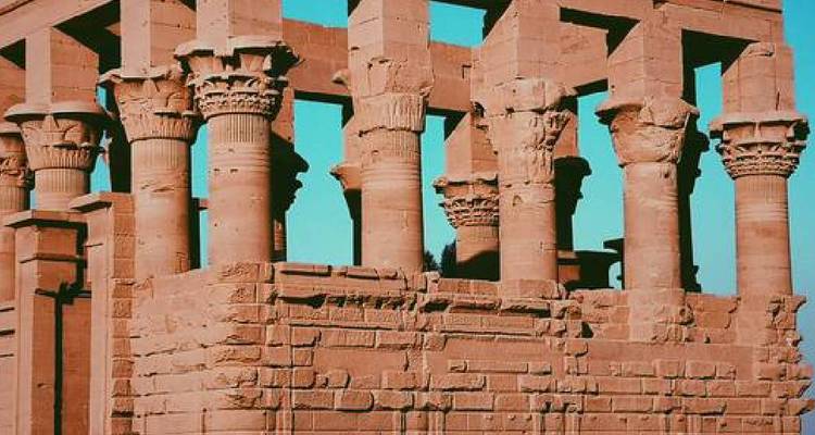 Een oude tempel met zuilen onder een blauwe hemel.