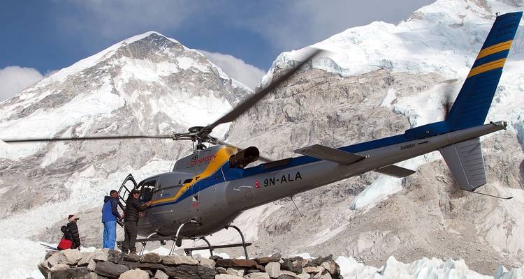 Helikopter geparkeerd in een besneeuwde omgeving met bergen.