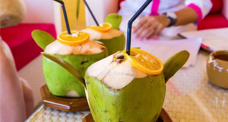 Noix de coco avec pailles et tranches d'orange