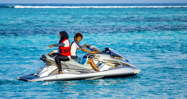 Deux personnes profitant d'une balade en jet ski par une journée ensoleillée.