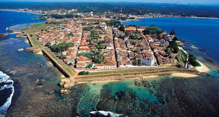 Vista aérea de un pueblo costero rodeado de agua turquesa.