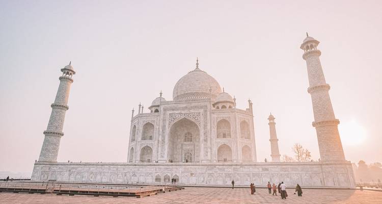 Le Taj Mahal avec des gens qui marchent devant et un ciel brumeux.