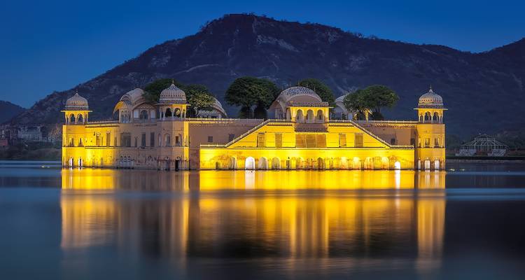 Jal Mahal illuminé et reflété sur l'eau la nuit.