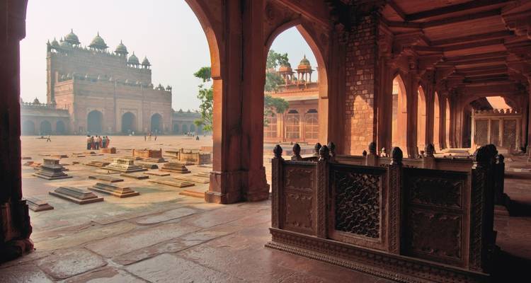 Couloir menant à une cour avec des bâtiments historiques.