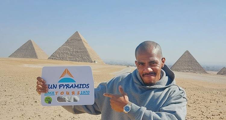 Ein Mann, der ein Schild hält, mit Pyramiden im Hintergrund.