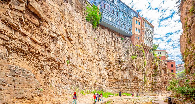 Bâtiments historiques construits à flanc de falaise rocheuse.