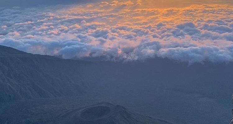 Coucher de soleil coloré sur un paysage montagneux et des nuages.