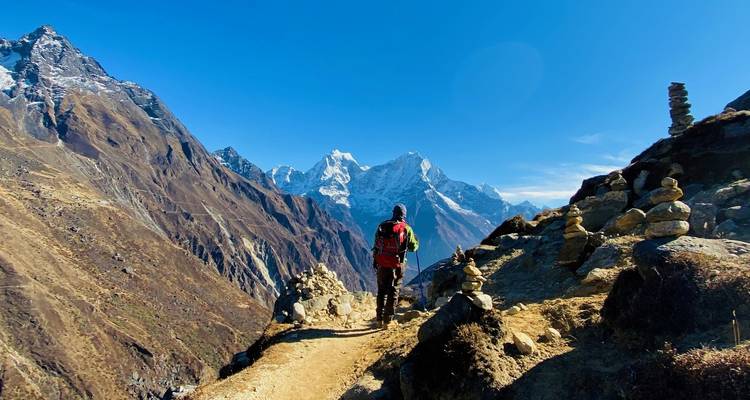 Persoon met rugzak wandelend op een schilderachtig bergpad.