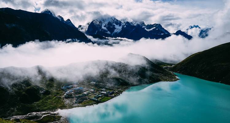 Vue panoramique de Gokyo avec lac turquoise et hauts sommets.