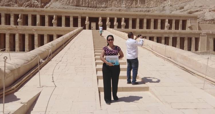 Frau, die ein Schild am Hatschepsut-Tempel hält.
