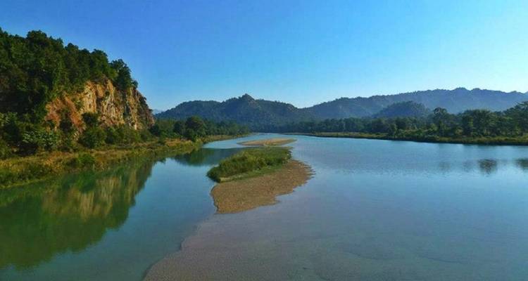 Malerische Aussicht auf einen Fluss, der sich durch eine üppige Landschaft schlängelt.