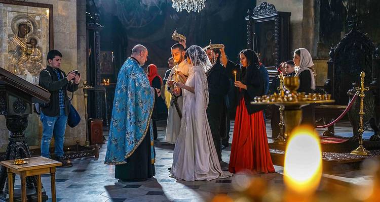 Priestly ceremony taking place inside an ornate church.