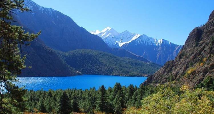 Uitzicht op een blauw meer met bergachtergrond.