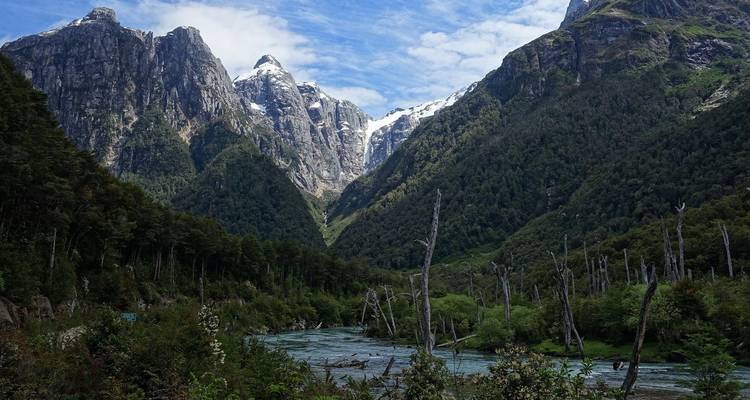 Majestisches Bergtal mit einem blauen Fluss, der hindurchfließt.