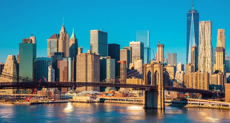 Sunset view of Manhattan skyline with the Brooklyn Bridge.