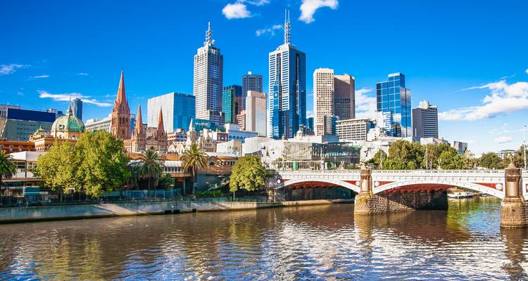 Melbourne city skyline with a bridge and river.