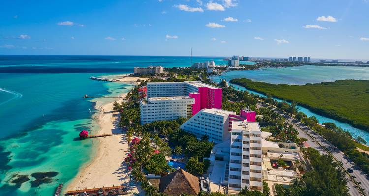 Bird's-eye view of a tropical beach surrounded by modern hotels.