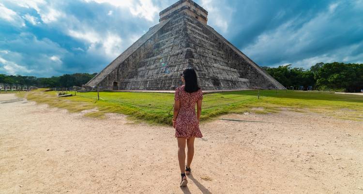A person walking towards the pyramid at Chichen Itza.