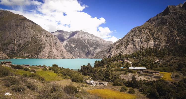 Een serene meer omgeven door ruige bergen onder een heldere blauwe hemel.