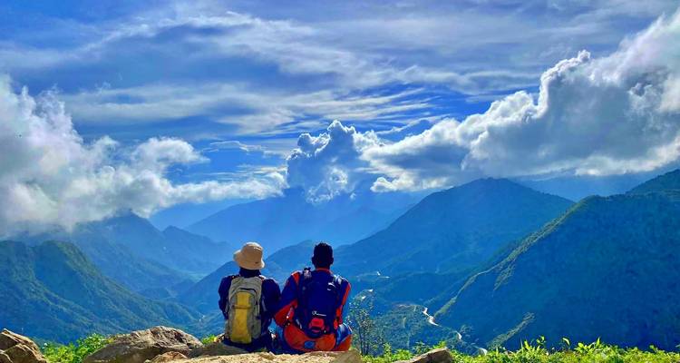 Twee wandelaars zitten en bewonderen het berglandschap.