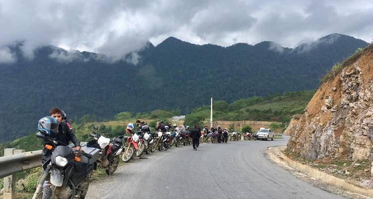 Rij motorfietsen met berijders op een bewolkte bergweg.