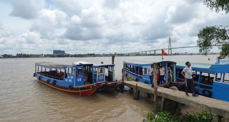 Pier met verschillende boten afgemeerd en mensen die in de buurt staan.
