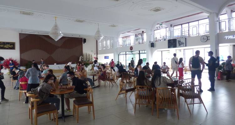 Binnen in een grote eetruimte met mensen die aan tafels zitten.