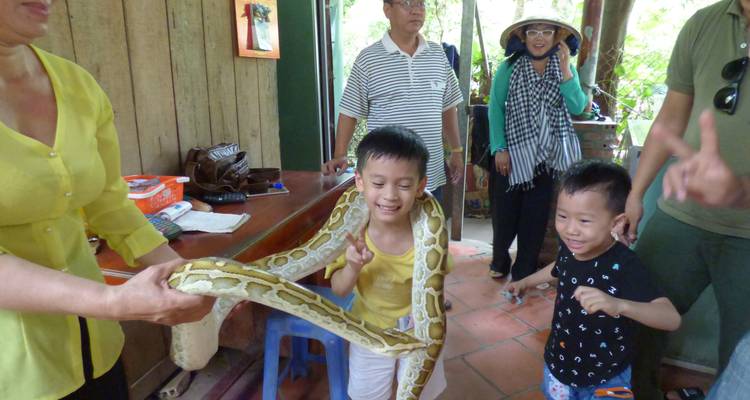 Kinderen en volwassenen die in een natuurlijke omgeving omgaan met een grote slang.