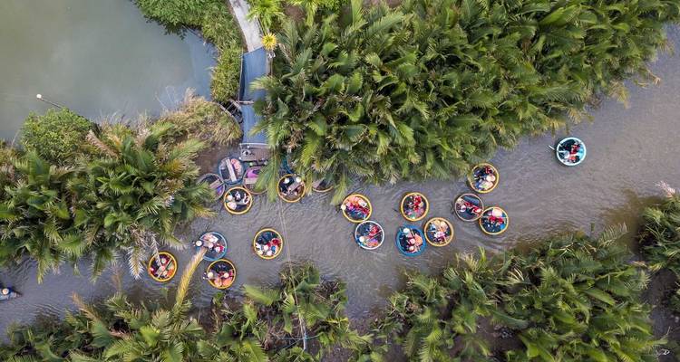 Aerial view of boats navigating through a forested waterway.