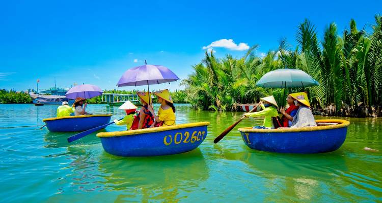 People in traditional circular boats using umbrellas on a sunny river.