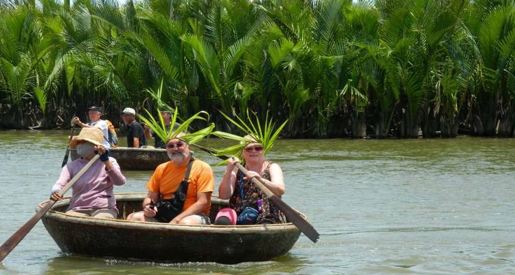 People paddling in round boats with palm fronds visible.