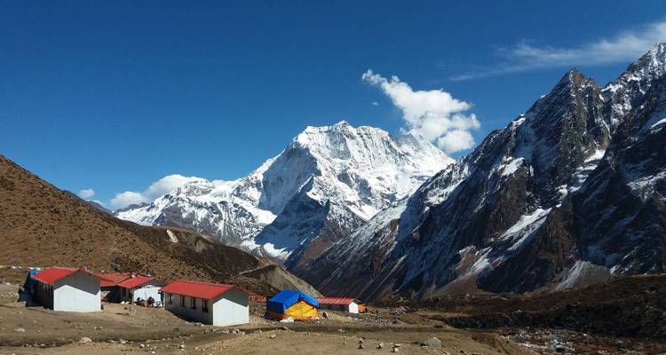 Mountain village with snow-capped peaks in the background.