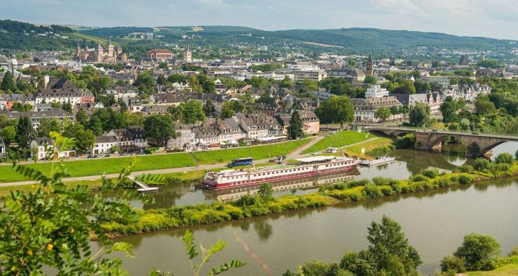 Vues d'une ville au bord d'une rivière avec un bateau amarré et des ponts.