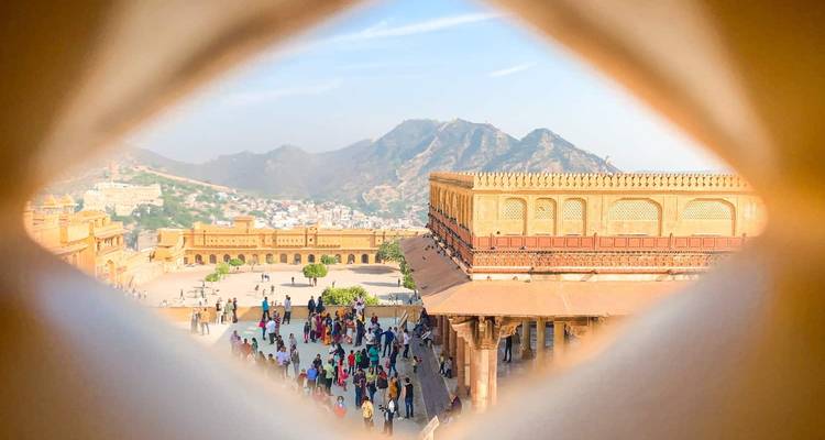 Vista del Fuerte de Ámbar y las colinas circundantes enmarcada por una ventana de celosía decorativa.