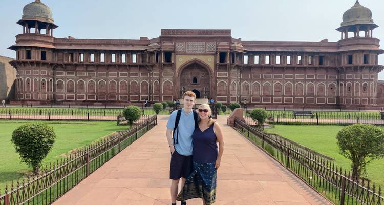 Mutter und Sohn posieren vor den roten Sandsteinmauern des Agra Fort an einem sonnigen Tag