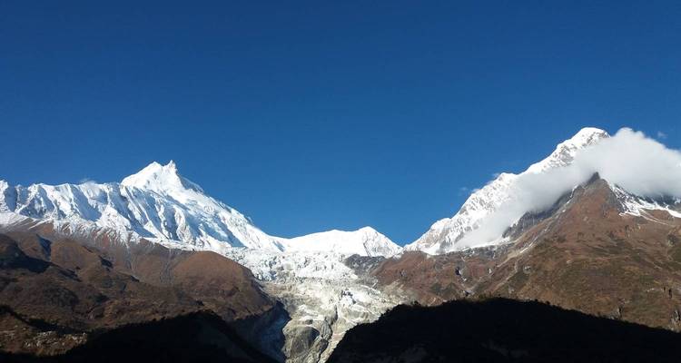 Hohes Gebirge mit Gletschern und blauem Himmel.