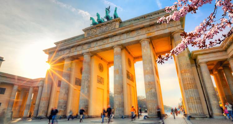Brandenburger Tor in Berlin bei Sonnenuntergang mit Kirschblüten.
