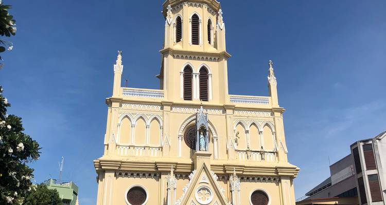 Yellow church with Gothic architectural style under a blue sky.