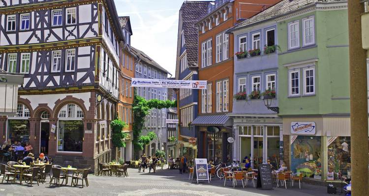 Colorful buildings in a town square with people dining.