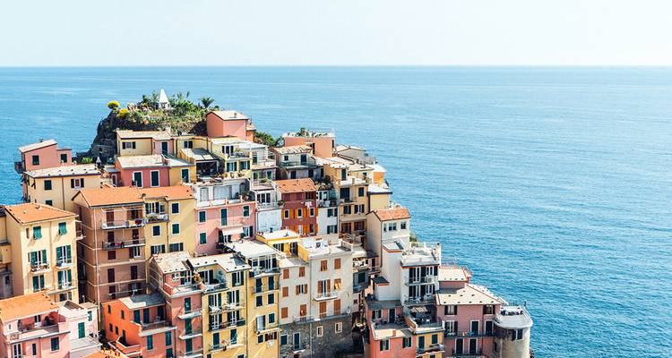Coloridos edificios en terrazas de un pueblo de Cinque Terre encaramado sobre el mar resplandeciente