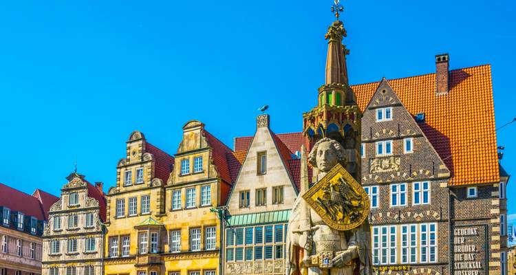 Statue devant des bâtiments historiques colorés.