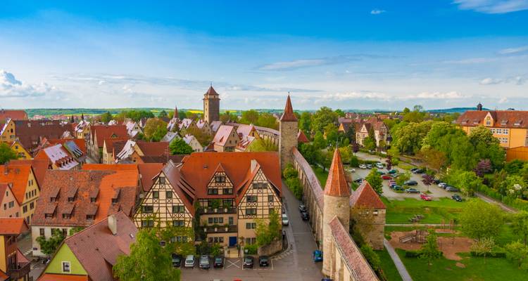 Mittelalterliche ummauerte Stadt mit rotgedeckten Gebäuden und Türmen.
