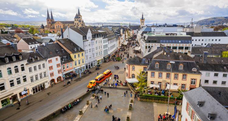 Vue aérienne d'une place de ville animée avec des bâtiments colorés et beaucoup de personnes.