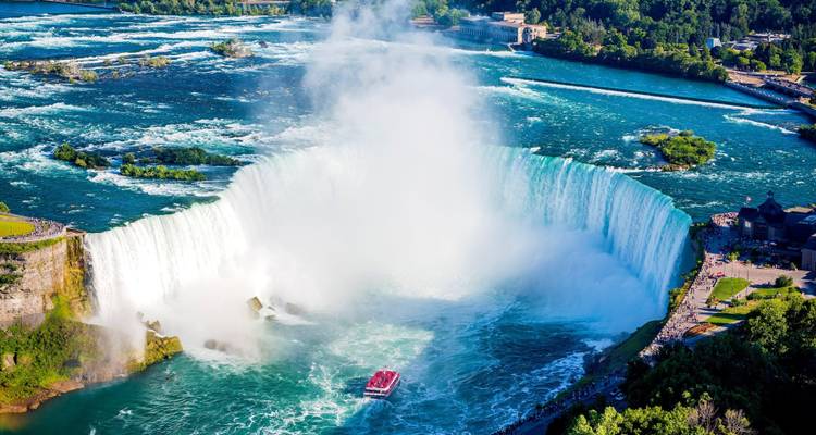Vue aérienne des Horseshoe Falls avec un bateau de tourisme affrontant les eaux brumeuses en contrebas.