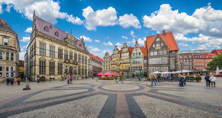 Stadsplein met historische gebouwen en een fontein.
