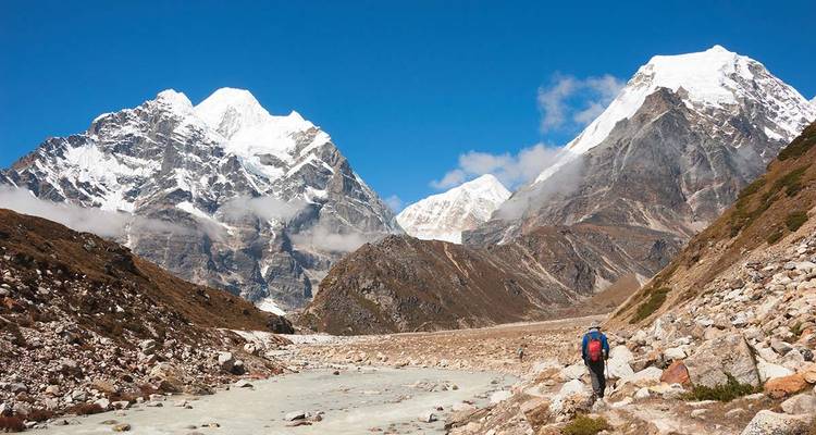 Wandelpad in een bergachtige vallei met besneeuwde toppen.