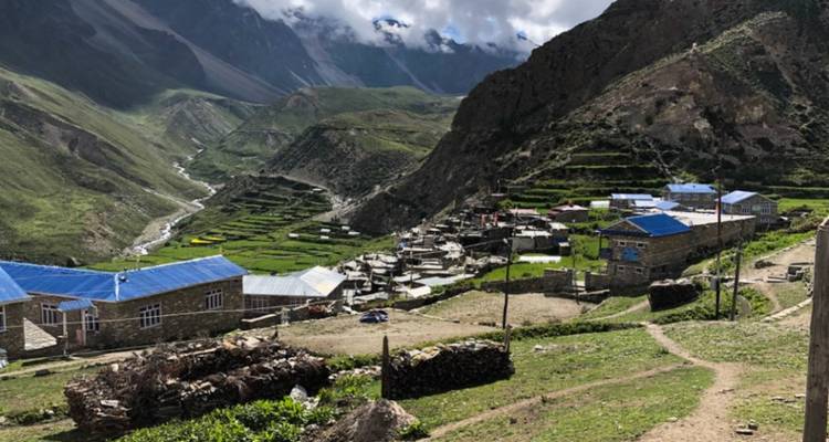 Scenic village nestled in a green valley with terraced fields.